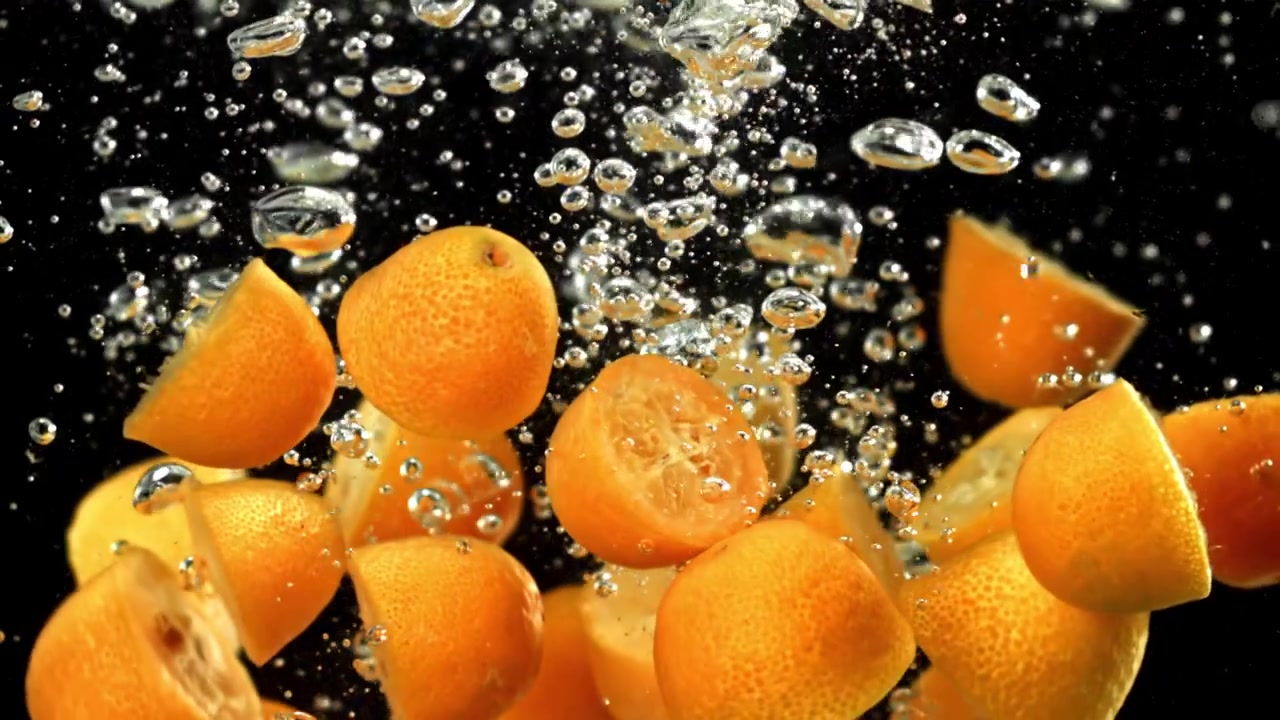 Slow Motion Fresh Kumquats Submerged in Bubbly Water