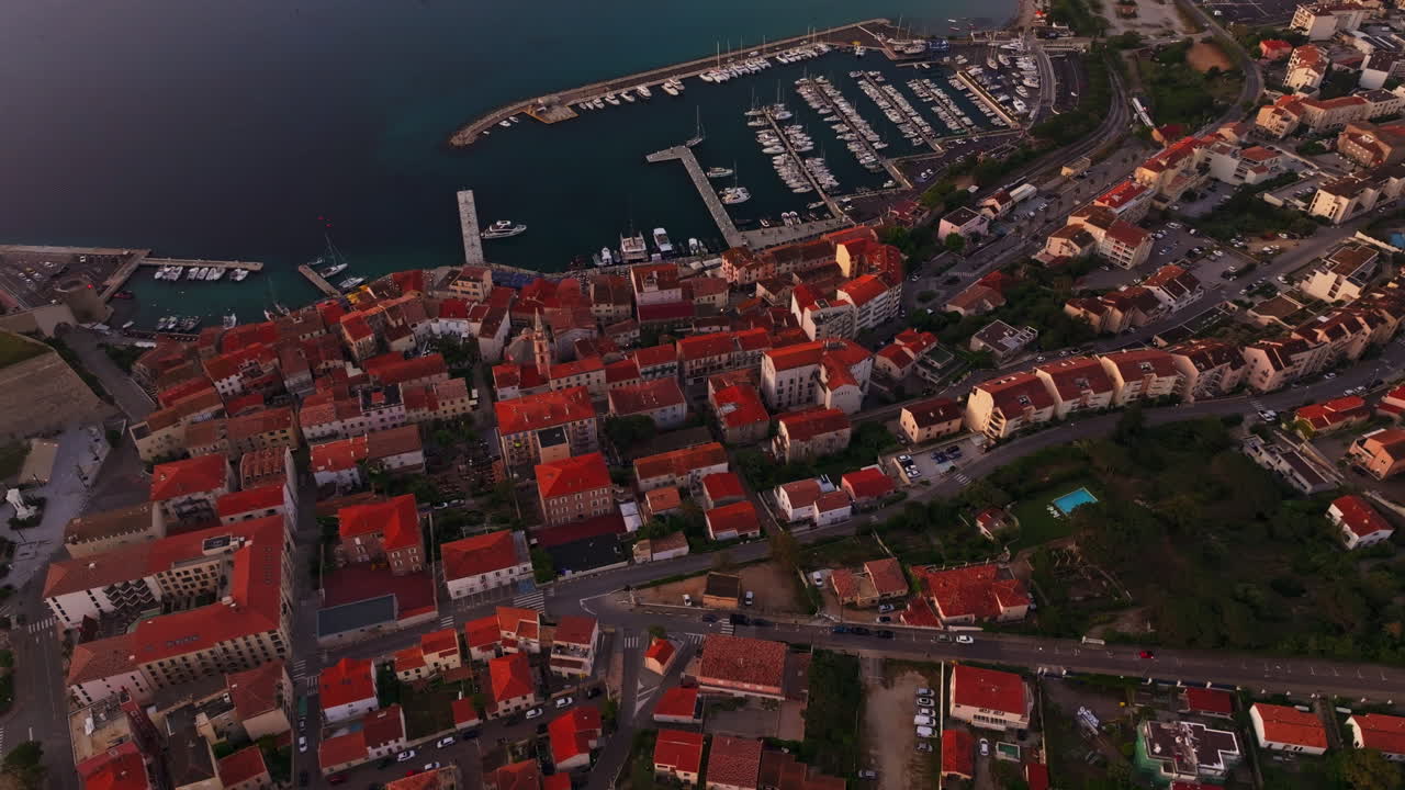 Top down aerial drone shot over the historic town of Calvi in Corsica, France High view of the harbor and red rooftops. Summer holidays destination