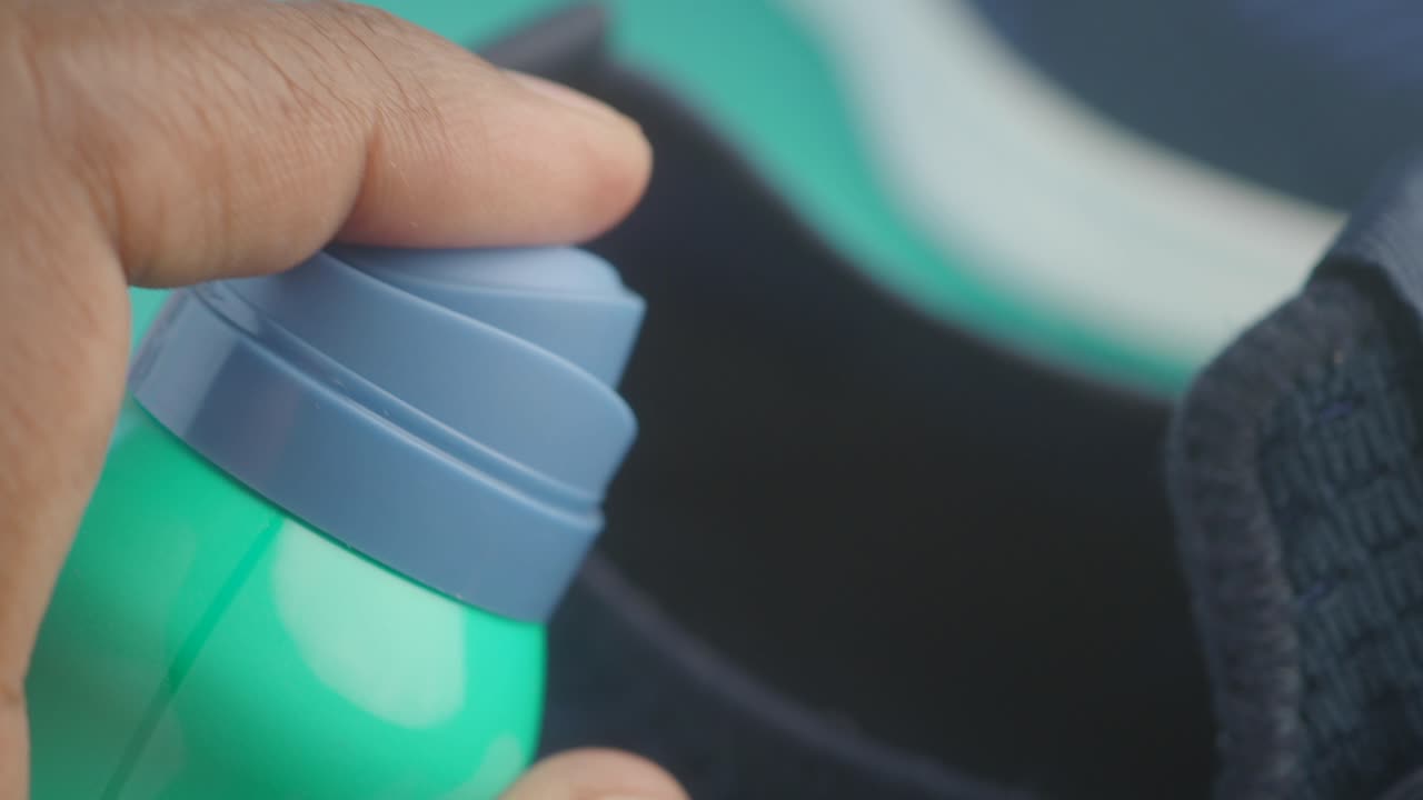 persona rociando un zapato con desodorante