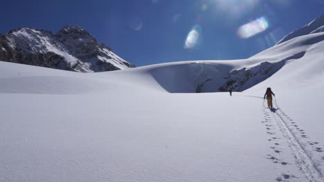 backcountry skiers ascending towards glacial ice cave