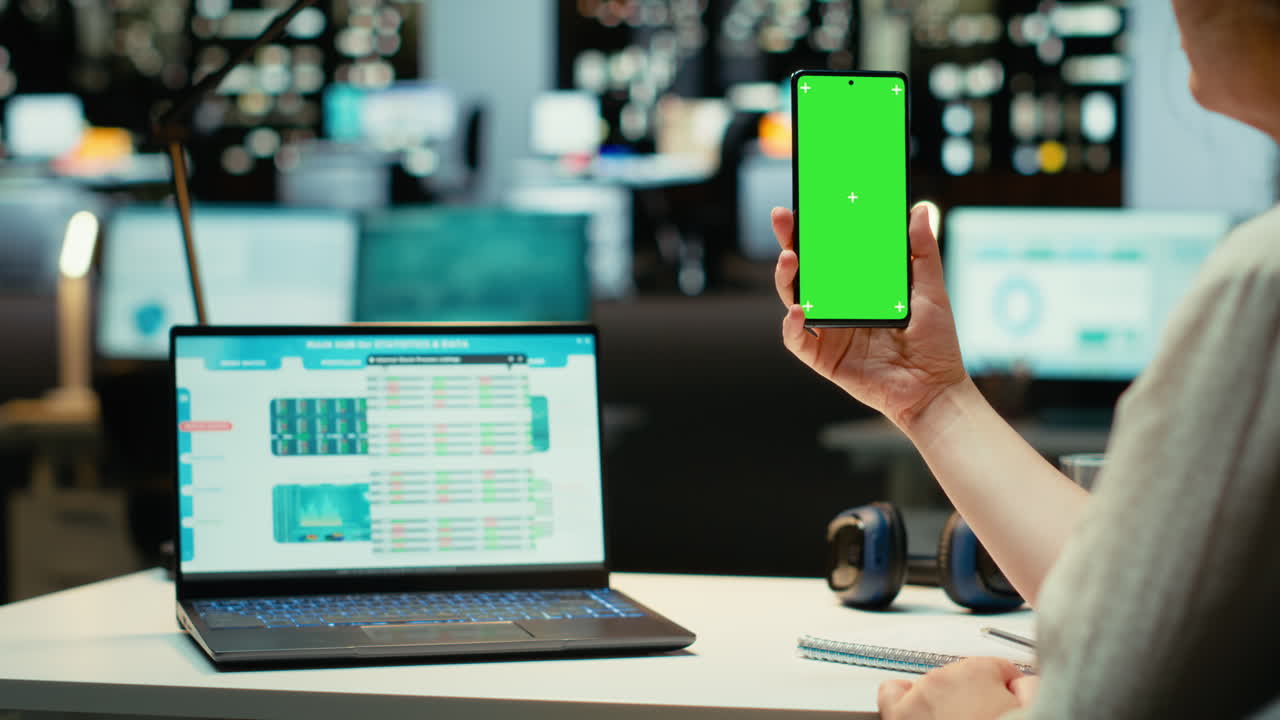 Vertical Video Businesswoman holds phone with chroma key at her desk for task management
