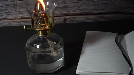 old hurricane oil lamp with an open book