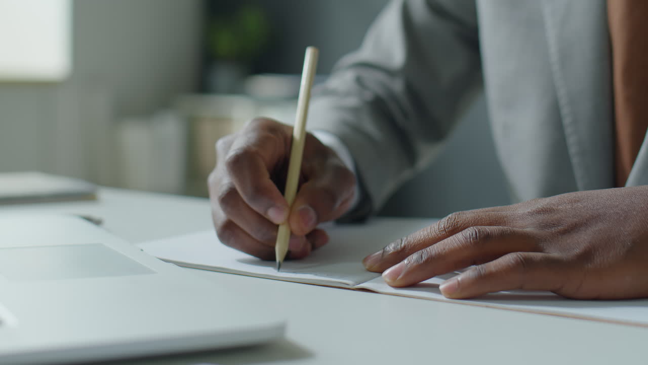 Hands of Black Businessman Taking Notes