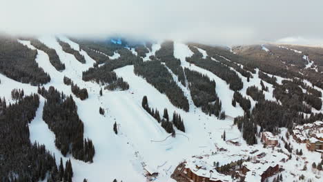 Foggy-cloud-layer-winter-snowy-early-morning-sunrise-aerial-drone-Copper-Mountain-Colorado-ski-resort-Eagle-Flyer-lift-center-village-half-pipe-Ikon-Epic-pass-snowboarding-backwards