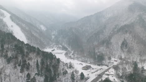 intersection road surrounded with snow covered forest in the mountains of northern japan alps in gifu, japan
