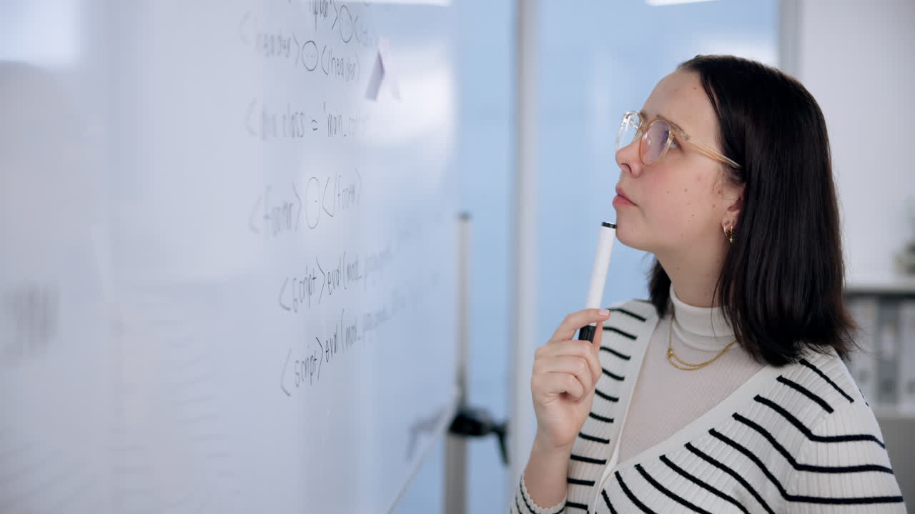 Woman writing code on whiteboard