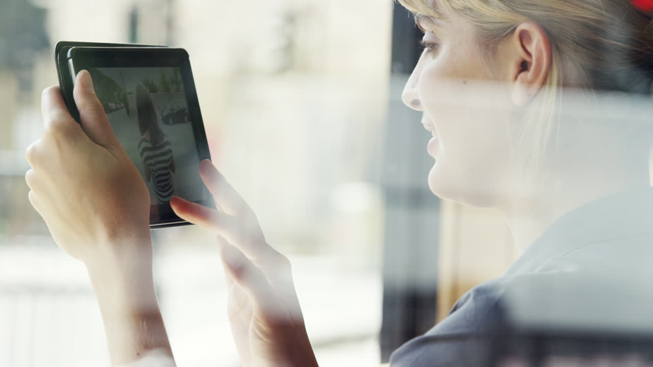Beautiful woman using digital tablet display ipad touchscreen in cafe