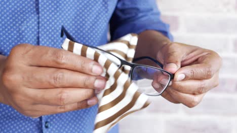 man cleaning his eyeglasses