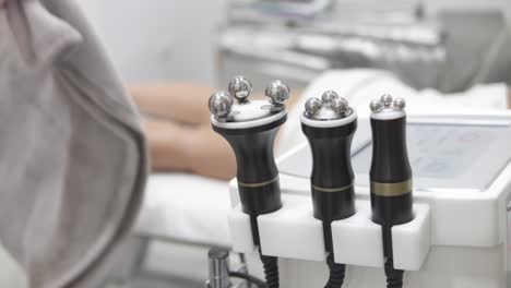 bokeh shot of electronic massagers with a masseuse preparing the patient in the background