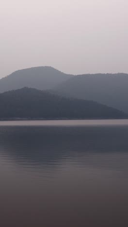 a serene lake landscape with mountains in the fog