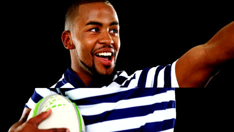 professional rugby sportsman holding a trophy and rugby ball