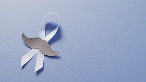 video of paper moustache and pale blue prostate cancer ribbon on pale blue background