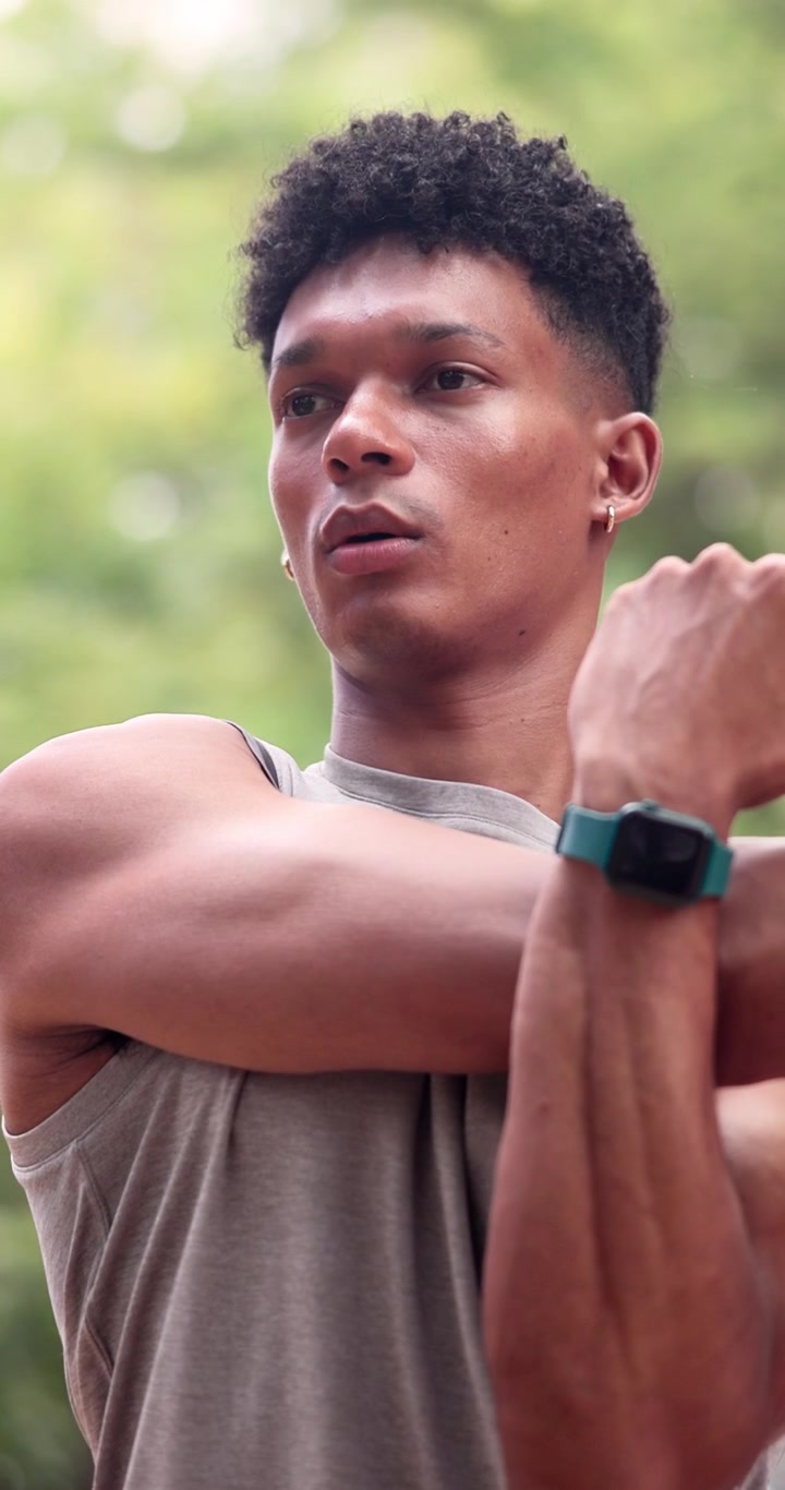 Young Man Stretching Arms Before Workout Outdoors