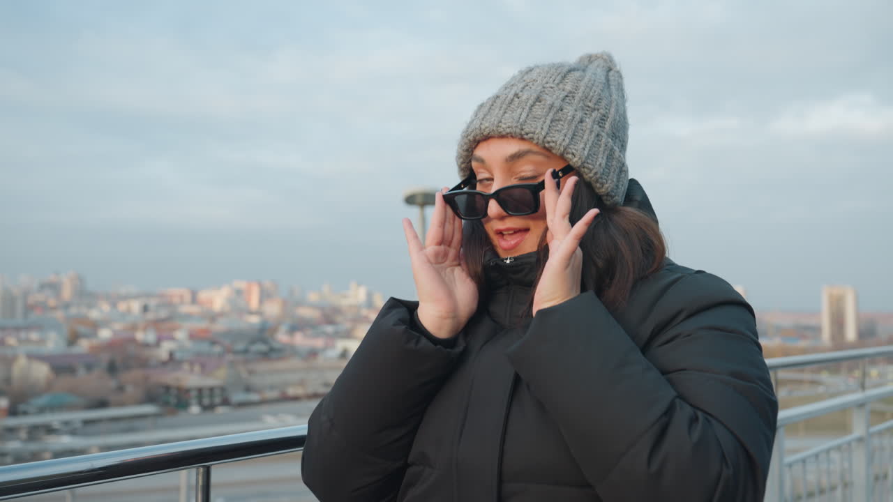 Closeup choreographic dance hands forward woman wearing sunglasses and knit hat executes expressive hand choreography, intimate portrait framing, cool winter tones, visible breath, confident gaze