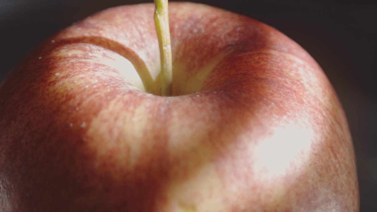 햇빛 반사와 함께 회전하는 빨간 사과. 극단적인 근접 촬영