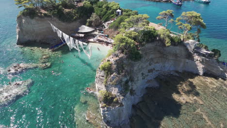 Luftaufnahme-Des-Cameo-Inselstrandes-Mit-Hängenden-Weißen-Stoffen,-Idyllischer-Sommerurlaubsort-Von-Zakynthos,-Griechenland