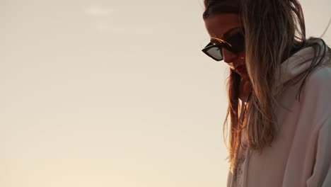 Slow-motion-shot-of-a-beautiful-female-wearing-a-hoodie-whilst-watching-the-sunset