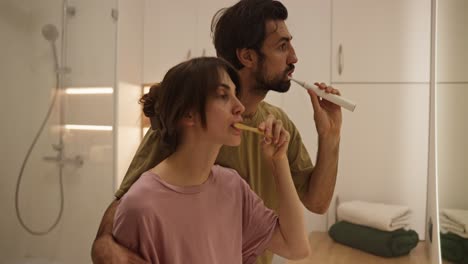 pareja cepillándose los dientes en el baño