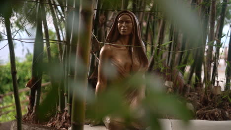 estatua de una mujer en un bosque de bambú del jardín zen para ayudar a la gente a relajarse y concentrarse en el interior