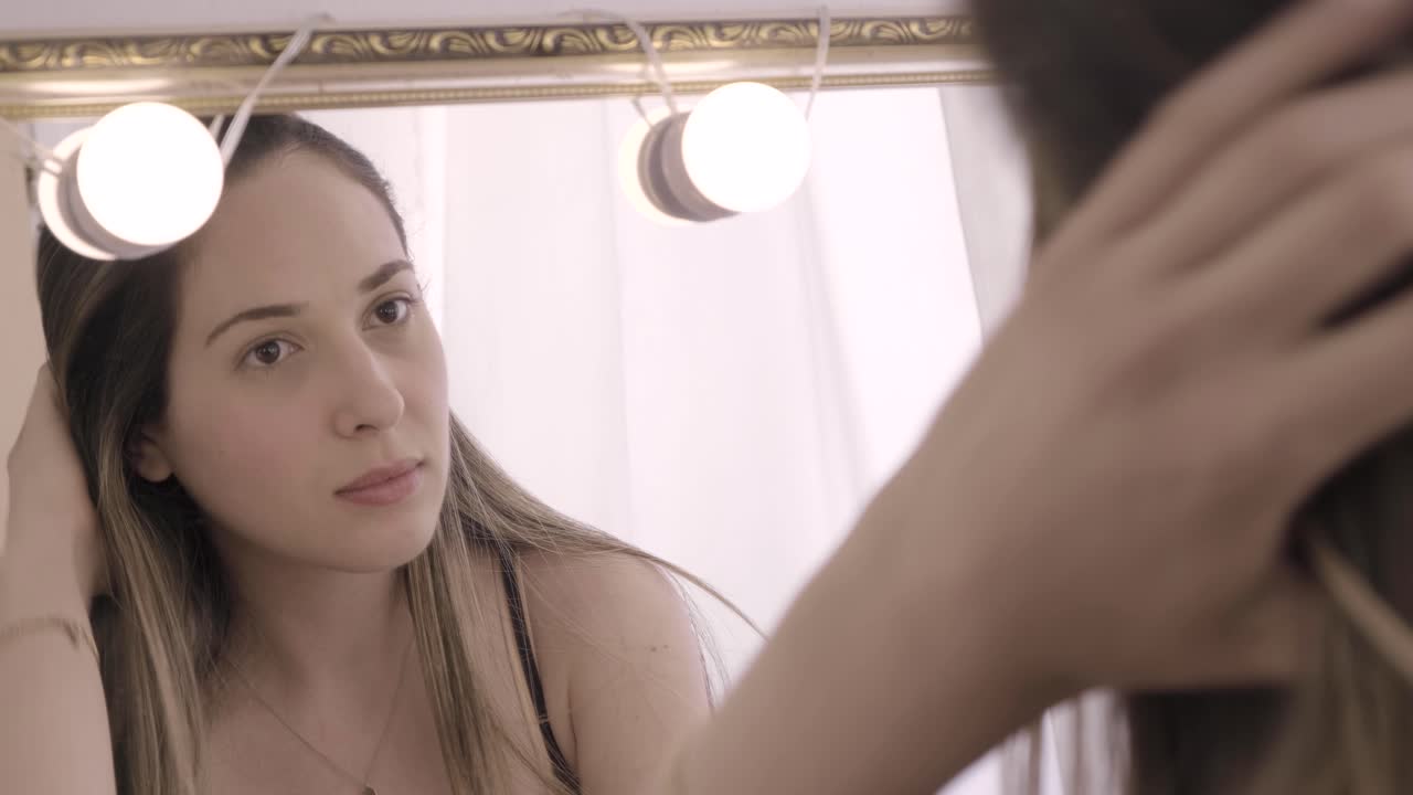 Primo piano di una giovane donna bianca che si guarda nello specchio