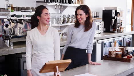 dos mujeres dueñas de negocios detrás del mostrador en su cafetería