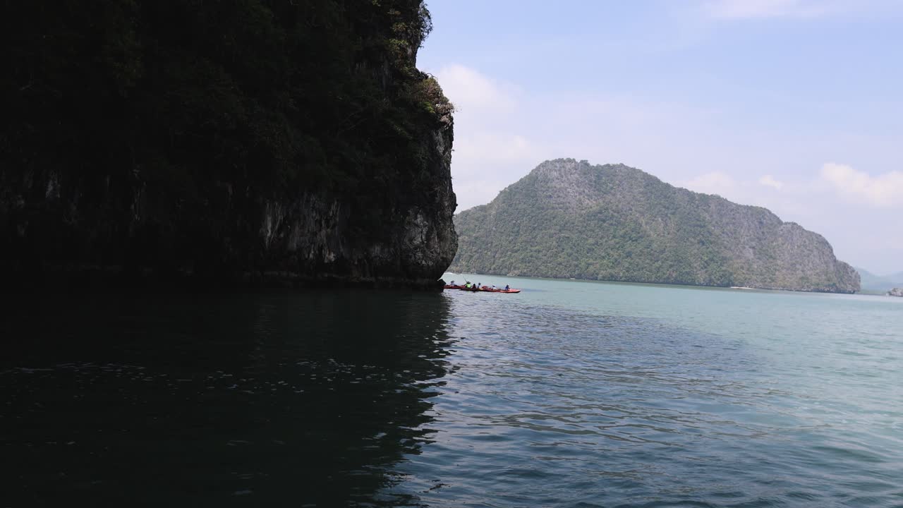절벽 과 경치 좋은 물 근처 에서 카야크 를 타는 사람 들