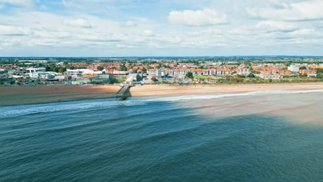 Drohnen-Videomaterial-Aus-Der-Luft,-Das-Vor-Der-Küste-Von-Lincolnshire-Aufgenommen-Wurde-Und-In-Richtung-Des-Piers-In-Skegness-Fliegt,-Mit-Strand,-Blauem-Meer-Und-Küstenlinie