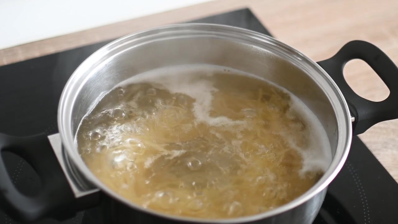 Cooking spaghetti in pot with boiling water