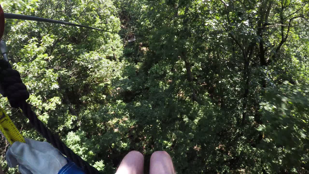Person in Harness Riding Zip Line through Georgia Forest Trees, POV