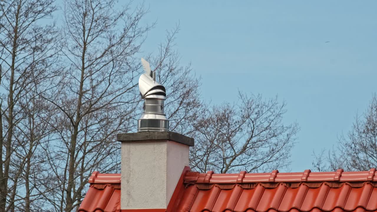 блестящий металлический дымоход вращающийся cao на вершине здания красная черепица крыша