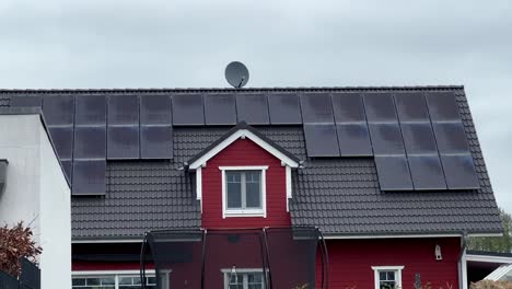 modern solar panels on rooftop of modern wooden red house