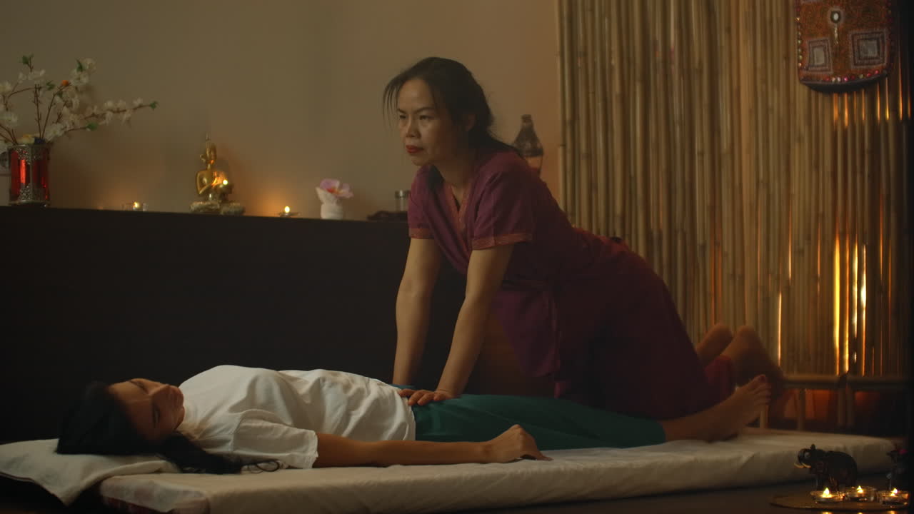 Asian Beautiful young Woman Enjoying Relaxing Receiving back Massage and Essential oil aroma therapy in Cosmetology spa Salon center. Body skin care beauty treatment concept.