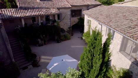 charming provençal stone farmhouse courtyard with gravel and umbrella