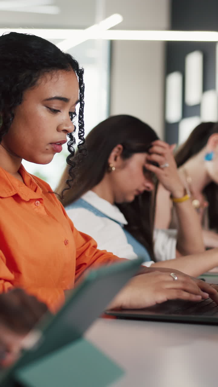 Giovane donna concentrata che digita sul laptop in ufficio