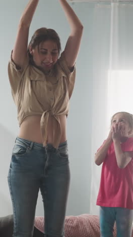 happy boy and scared girl look at mother breaking piggy bank on sofa in living room slow motion. children and woman unpack savings. funny attraction