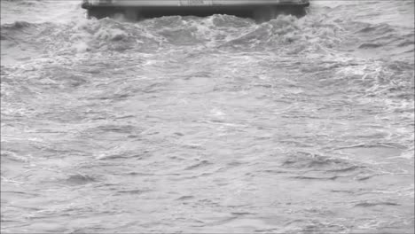 un paseo en bote clipper en el río támesis, londres, reino unido, visto desde la parte trasera donde los motores impulsan el bote de pasajeros a través del agua
