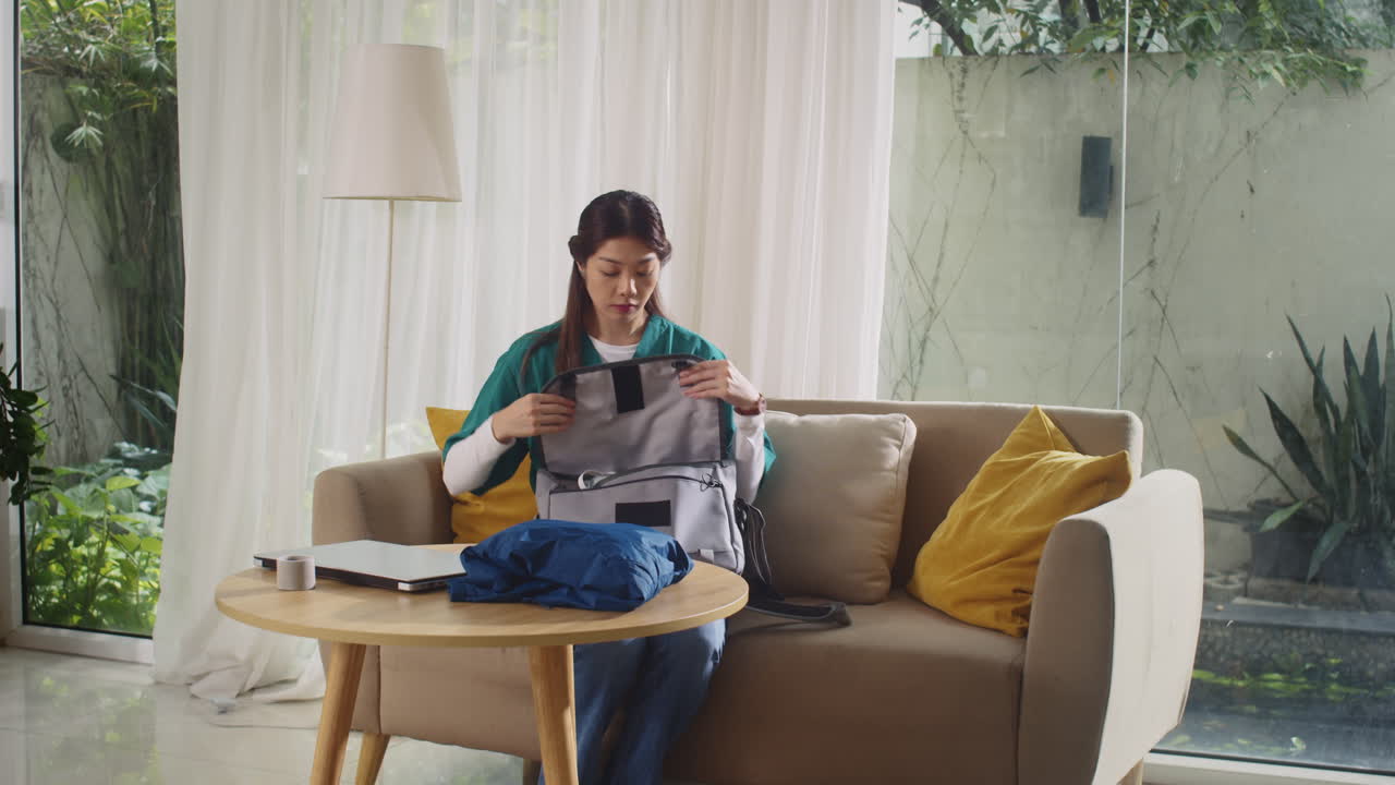 Vertical of Nurse in Uniform Putting Phone in Bag when Preparing for Work