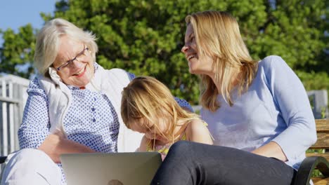 multi-generation family looking at photo album in garden 4k