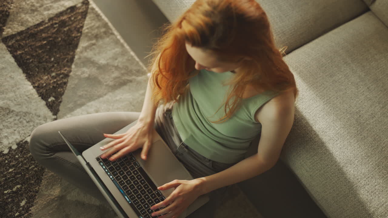 mujer usando una computadora portátil sentada en el suelo