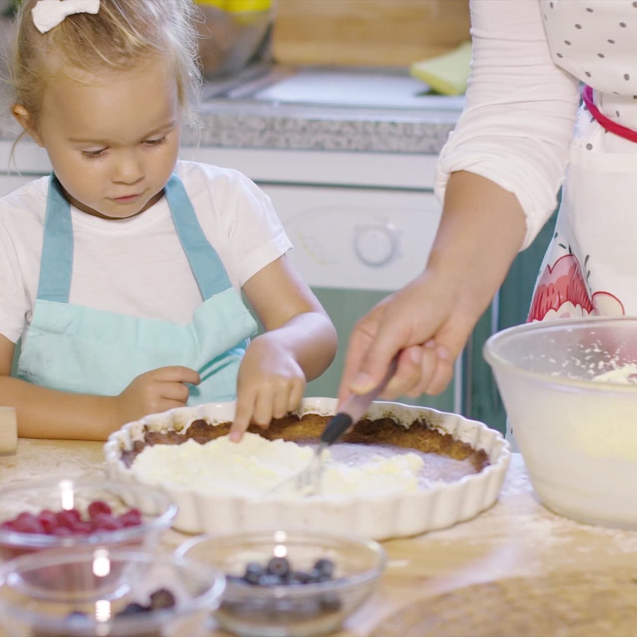 niña bonita aprendiendo a hornear un pastel de bayas