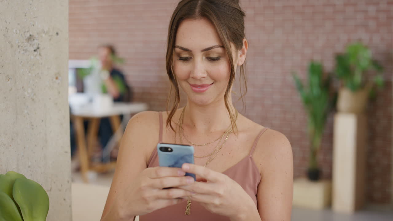 retrato de una hermosa mujer joven usando un teléfono inteligente enviando mensajes de texto navegando en línea feliz leyendo mensajes de redes sociales en el trabajo