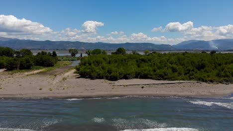 agua de mar turquesa que lava la playa de arena y vegetación exuberante que separa la laguna natural, hermoso paisaje mediterráneo visto desde arriba