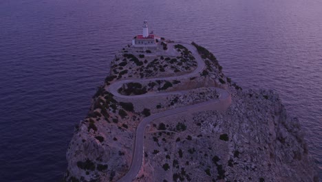 drone view of mallorca famous lighthouse located on top of a cliff during sunrise, aerial