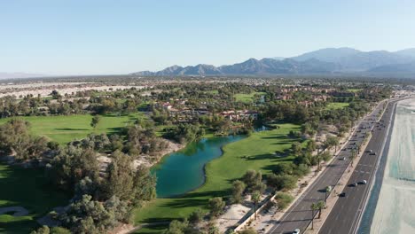 Amplia-Toma-Aérea-Sobrevolando-Un-Vibrante-Campo-De-Golf-En-Palm-Desert