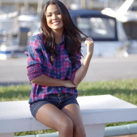 young woman sitting on bench in harbor