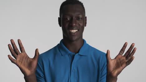 un hombre afroamericano gracioso sobre un fondo gris.