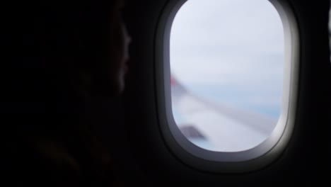 4k silhouette of young asian woman looking out off airplane window