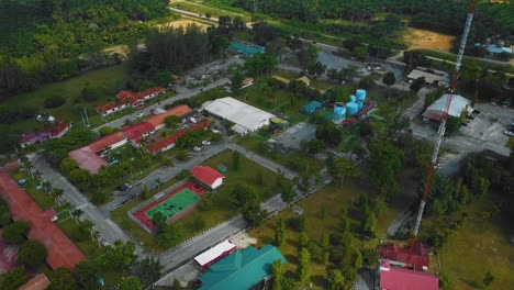 Cinematic-Drone-Footage-of-Palm-Oil-Mill-Effluent-residential-consists-of-buildings,-homes,-main-road-and-infrastructure-surrounded-by-palm-oil-trees-deforestation-located-in-Indonesia-in-full-HD