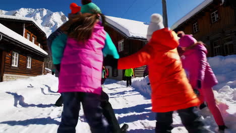 children playing in snow-covered village by the mountains