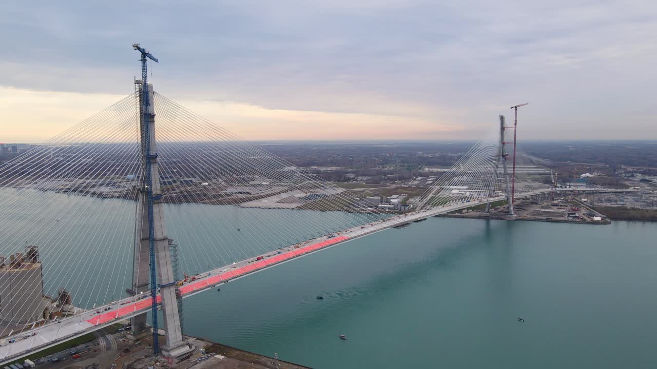Drone video of Gordie Howe International Bridge nearing completion during sunset